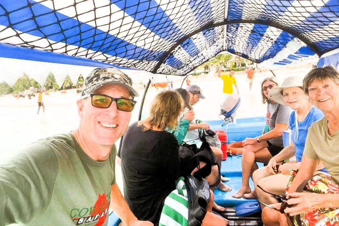 Guests seated inside a covered boat by the beach