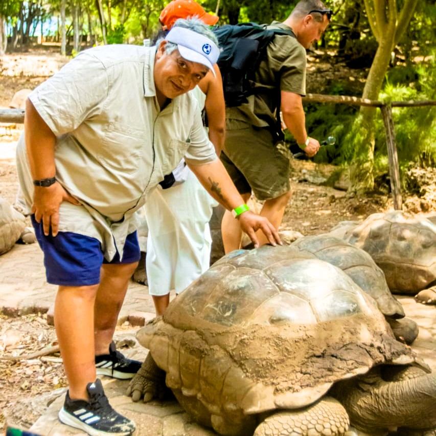 Visitor touching a giant tortoise on Prison Island